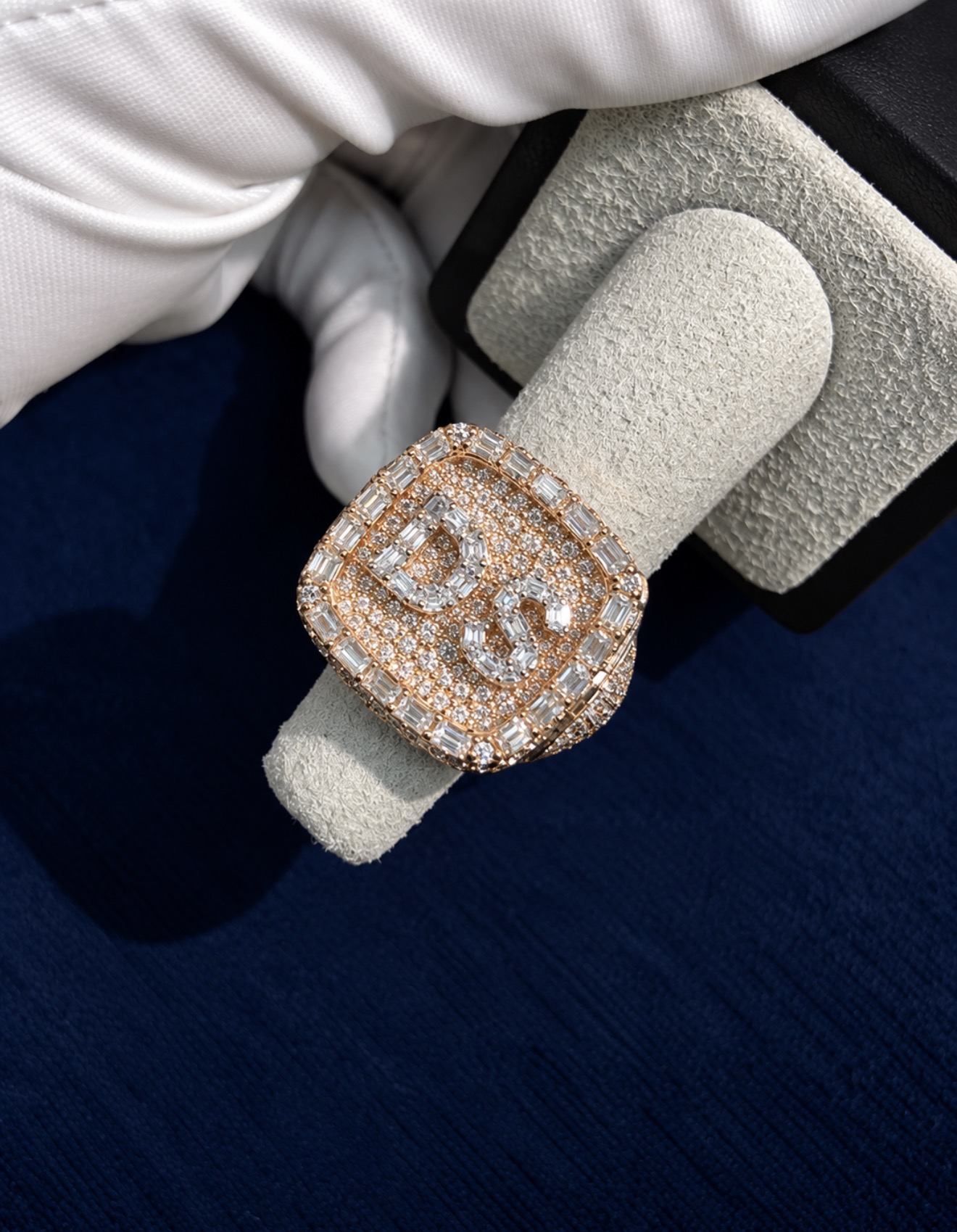 Custom iced championship ring on a display stand, face set with moissanite